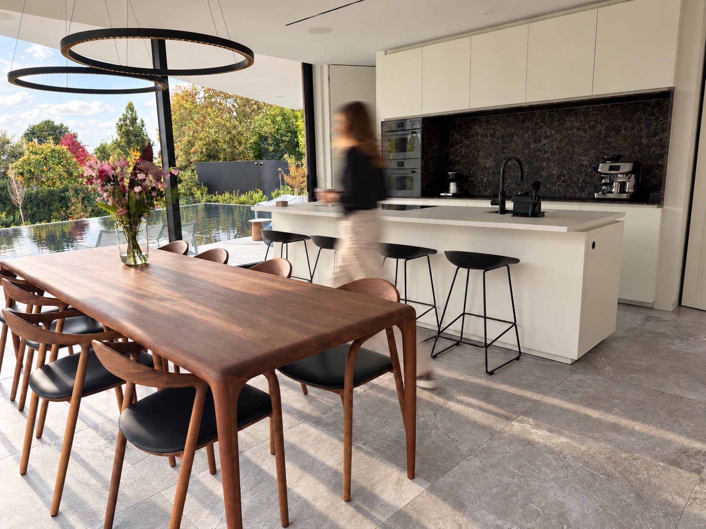 Our First Habitat kitchen in natural sunlight, with a motion-blurred person and a reflective overflow pool outside